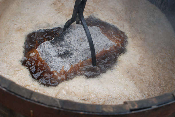 Lower hot stones into wort at Scratch Brewing